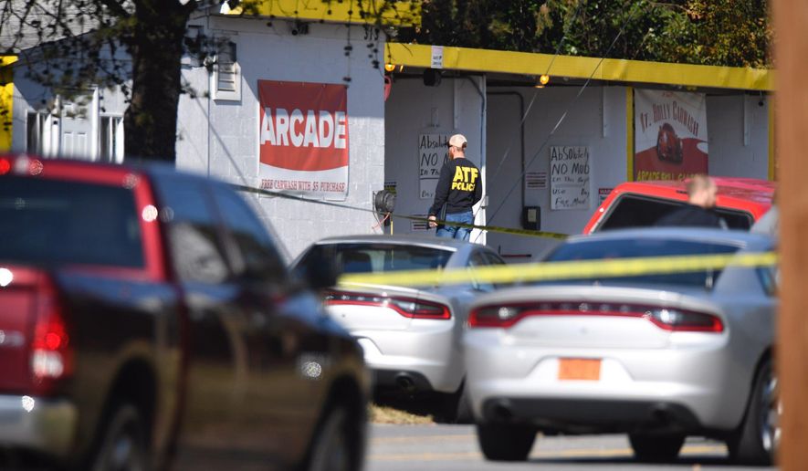Law enforcement investigators survey the scene of a shooting at a car wash in the Belmont area of Gaston County, N.C. Friday, Dec. 11, 2020. A North Carolina police officer has been killed in a shootout while responding to a breaking and entering call early Friday morning. Authorities say Mount Holly police officer Tyler Herndon was shot during a shootout between the breaking and entering suspect and police officers. (David Foster/The News & Observer via AP)