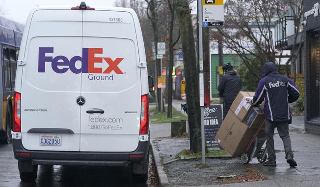 A driver with FedEx carries a package away from a van, Tuesday, Dec. 8, 2020, in Seattle. Store are warning online shoppers that if holiday purchases aren&#x27;t made soon, they may not be delivered in time for Christmas. (AP Photo/Ted S. Warren)