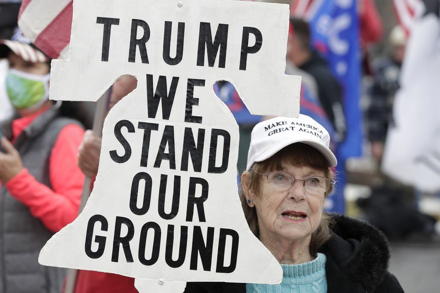 A supporter of President Donald Trump attends a rally at Freedom Plaza, Saturday, Dec. 12, 2020, in Washington. (AP Photo/Luis M. Alvarez)