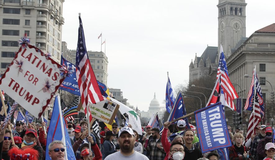 With the U.S. Capitol building in the background, supporters of President Donald Trump demonstrate during a rally at Freedom Plaza, Saturday, Dec. 12, 2020, in Washington. (AP Photo/Luis M. Alvarez)