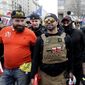 Supporters of President Donald Trump who are wearing attire associated with the Proud Boys watch during a rally at Freedom Plaza, Saturday, Dec. 12, 2020, in Washington. (AP Photo/Luis M. Alvarez)
