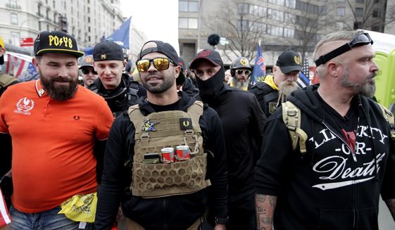 Supporters of President Donald Trump who are wearing attire associated with the Proud Boys watch during a rally at Freedom Plaza, Saturday, Dec. 12, 2020, in Washington. (AP Photo/Luis M. Alvarez)
