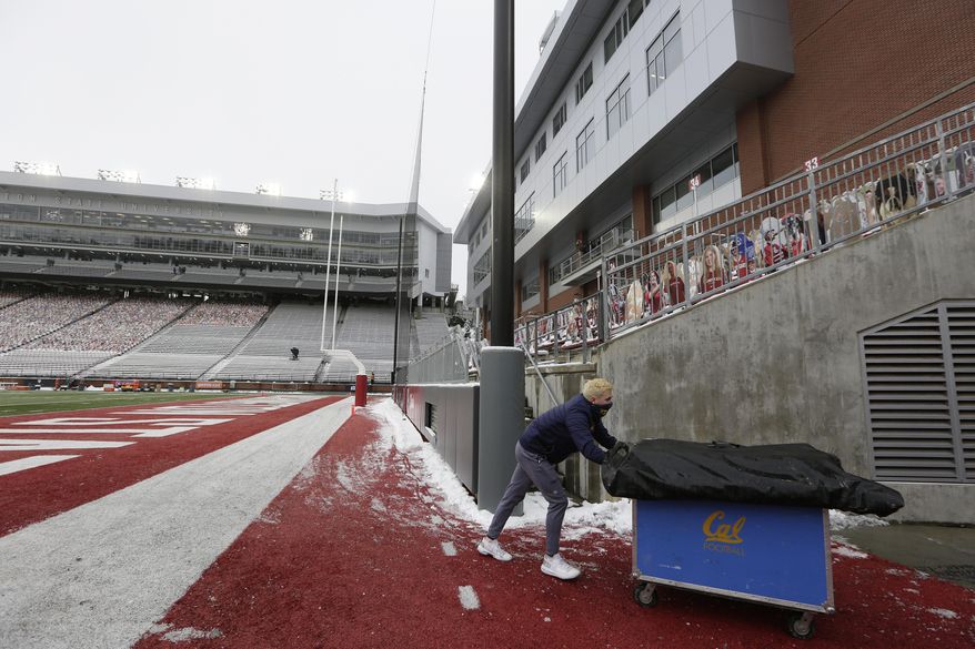 California student equipment manager Will O'Connor removes equipment for his team from Martin Stadium after the NCAA college football game between Washington State and California was canceled because of a case of COVID-19 on the Cal team, Saturday, Dec. 12, 2020, in Pullman, Wash. (AP Photo/Young Kwak)