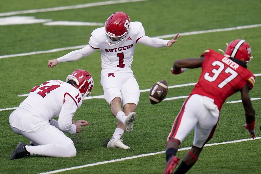 Rutgers kicker Valentino Ambrosio (1), with Zach Feagles holding, attempts a field goal as Maryland's Lavonte Gater rushes in during the first half of an NCAA college football game, Saturday, Dec. 12, 2020, in College Park, Md. Ambrosio missed the kick. (AP Photo/Julio Cortez)