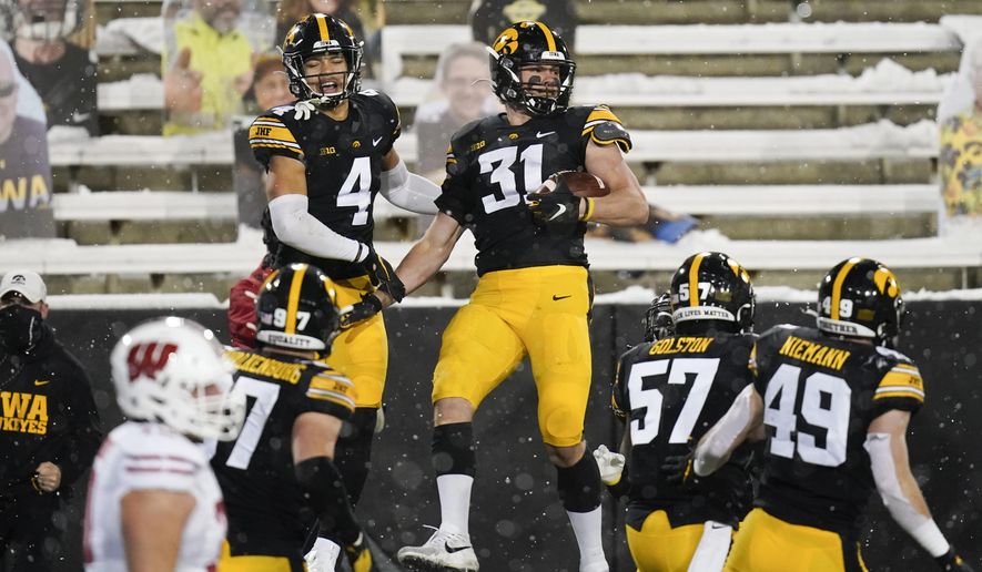 Iowa linebacker Jack Campbell (31) celebrates with teammate Dane Belton (4) after intercepting a pass during the second half of an NCAA college football game against Wisconsin, Saturday, Dec. 12, 2020, in Iowa City, Iowa. Iowa won 28-7. (AP Photo/Charlie Neibergall)