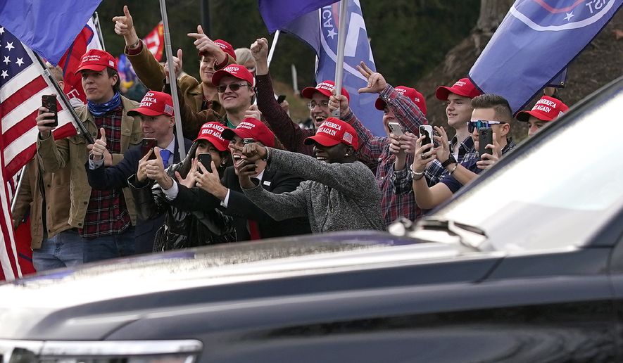 Supporters of President Donald Trump react as his motorcade departs Trump National Golf Club in Sterling, Va., Sunday, Dec. 13, 2020. (AP Photo/Patrick Semansky)