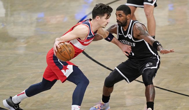 Brooklyn Nets guard Kyrie Irving (11) defends Washington Wizards forward Deni Avdija (9) as Avdija drives toward the Wizards basket during the second quarter of a preseason NBA basketball game, Sunday, Dec. 13, 2020, in New York. (AP Photo/Kathy Willens)  **FILE**