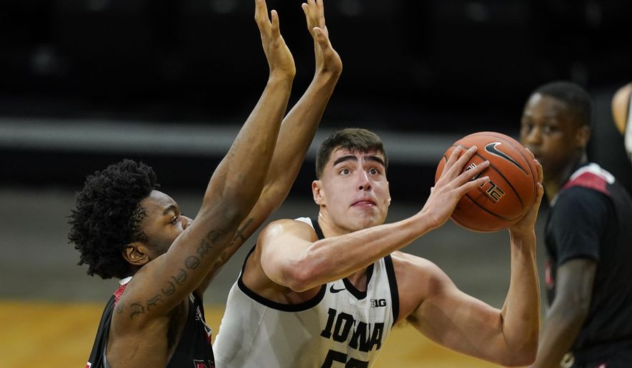 Iowa center Luka Garza drives to the basket ahead of Northern Illinois forward Chinedu Okanu, left, during the first half of an NCAA college basketball game, Sunday, Dec. 13, 2020, in Iowa City, Iowa. (AP Photo/Charlie Neibergall)
