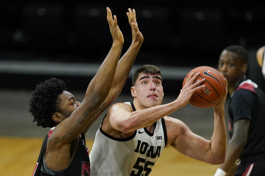 Iowa center Luka Garza drives to the basket ahead of Northern Illinois forward Chinedu Okanu, left, during the first half of an NCAA college basketball game, Sunday, Dec. 13, 2020, in Iowa City, Iowa. (AP Photo/Charlie Neibergall)