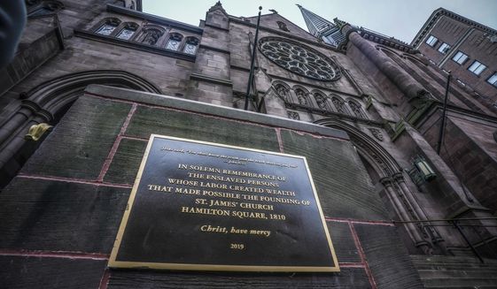 A plaque sits at the steps of St. James Episcopal Church, Friday Dec. 4, 2020, in New York&#x27;s Upper East Side neighborhood, acknowledging the church&#x27;s wealth created with slave labor. (AP Photo/Bebeto Matthews)