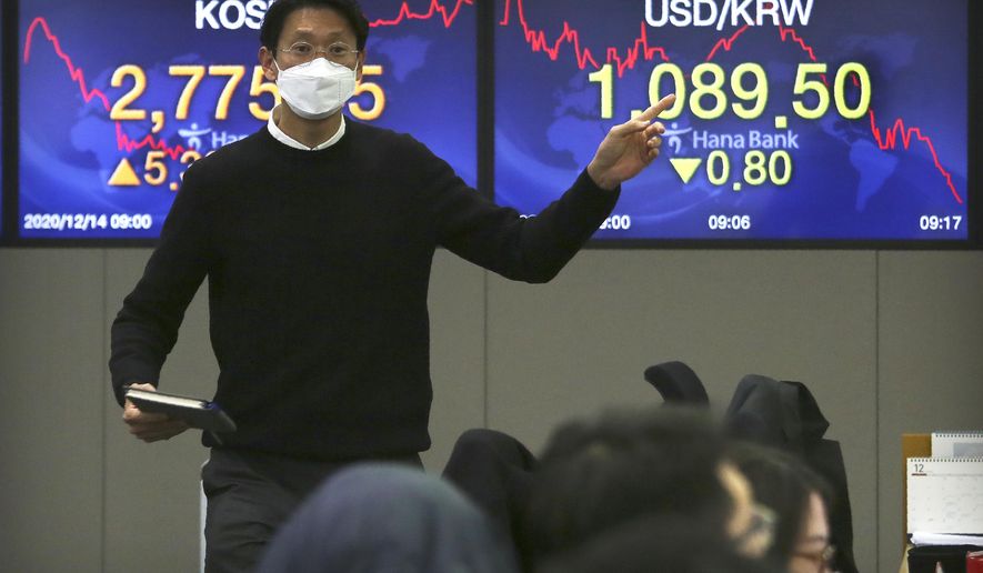 A currency gestures as he talks with his colleagues at the foreign exchange dealing room of the KEB Hana Bank headquarters in Seoul, South Korea, Monday, Dec. 14, 2020. Shares were mostly higher in Asia on Monday as the Bank of Japan&#39;s quarterly &amp;quot;tankan&amp;quot; survey showed stronger than expected business sentiment in a further sign the economy is recovering from recession. (AP Photo/Ahn Young-joon)