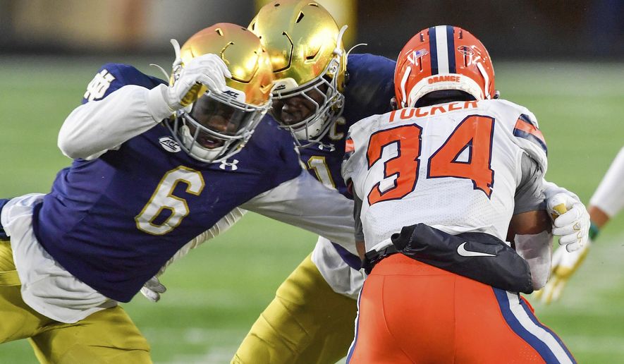 Syracuse running back Sean Tucker (34) is tackled by Notre Dame linebacker Jeremiah Owusu-Koramoah (6) during the third quarter of an NCAA college football game Saturday, Dec. 5, 2020, in South Bend, Ind. (Matt Cashore/Pool Photo via AP) **FILE**