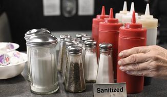 Head waitstaff Laurie Mitchell, places cleaned ketchup bottles together at Rodd&#39;s Restaurant, Thursday, Dec. 10, 2020, in Bristol, Conn. (AP Photo/Jessica Hill) ** FILE **