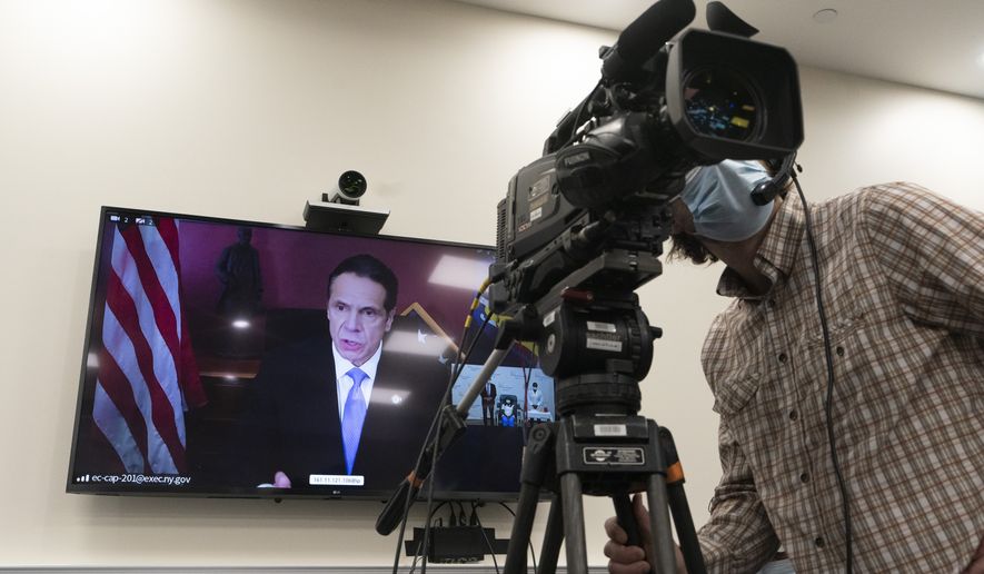 Gov. Andrew Cuomo participates in a video conference call after a nurse was inoculated with the Pfizer-BioNTech COVID-19 vaccine, Monday, Dec. 14, 2020, at the Long Island Jewish Medical Center, in the Queens borough of New York.  (AP Photo/Mark Lennihan)