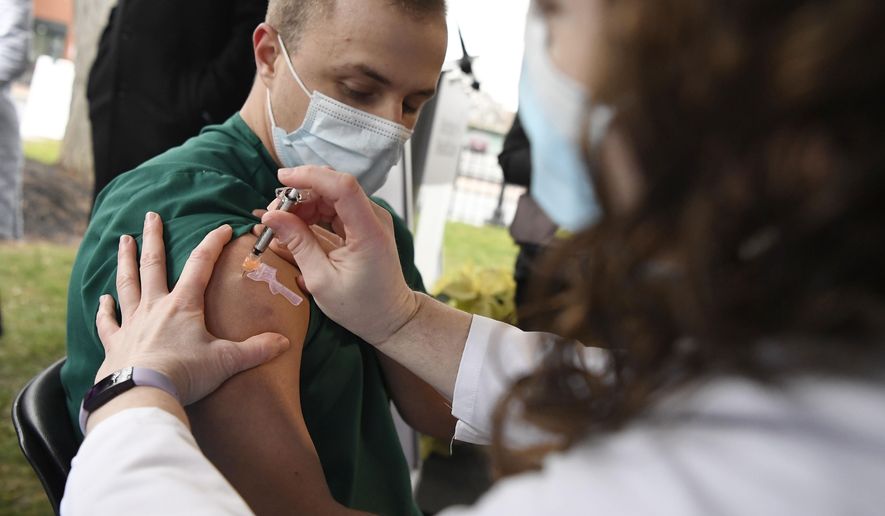 Colleen Teevan, System Pharmacy Clinical Manager at Hartford HealthCare, administers the Pfizer-BioNTech vaccine for COVID-19 to healthcare worker Connor Paleski outside of Hartford Hospital, Monday, Dec. 14, 2020, in Hartford, Conn. (AP Photo/Jessica Hill)
