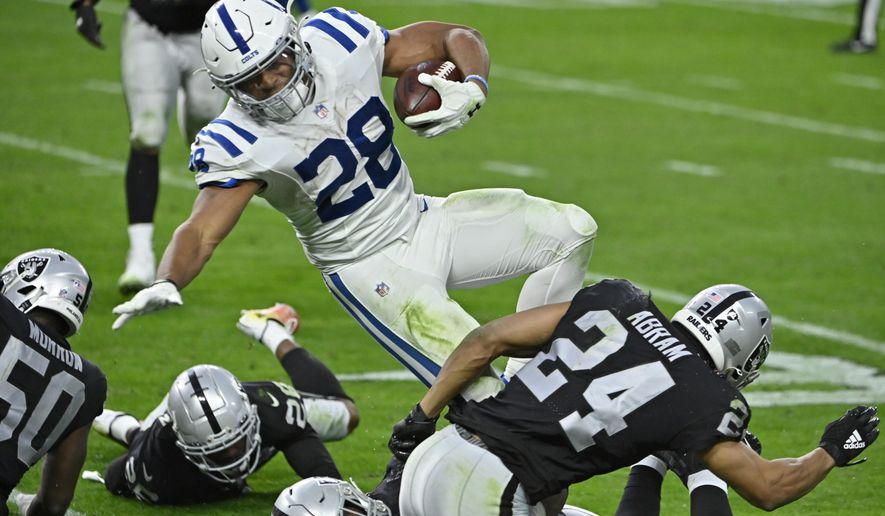 Las Vegas Raiders strong safety Johnathan Abram (24) tackles Indianapolis Colts running back Jonathan Taylor (28) during the second half of an NFL football game, Sunday, Dec. 13, 2020, in Las Vegas. (AP Photo/David Becker)