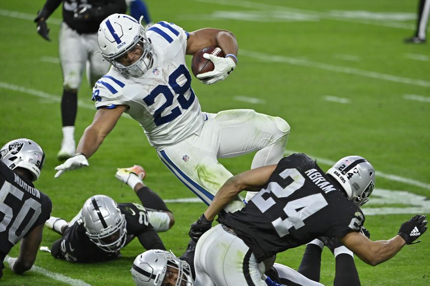 Las Vegas Raiders strong safety Johnathan Abram (24) tackles Indianapolis Colts running back Jonathan Taylor (28) during the second half of an NFL football game, Sunday, Dec. 13, 2020, in Las Vegas. (AP Photo/David Becker)