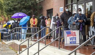 People wait in line on the first day of advance voting for Georgia&#39;s Senate runoff election at the Bell Auditorium in Augusta, Ga., Monday, Dec. 14, 2020. (Michael Holahan/The Augusta Chronicle via AP)