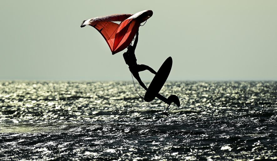 A wing-surfer catches some air on lake Ontario at Cherry Beach on a warm fall day during the COVID-19 pandemic in Toronto on Friday, Nov. 20, 2020. Meteorologists say it'll be close but it's looking like 2020 globally will end up as the hottest year on record. The National Oceanic and Atmospheric Administration said Monday, Dec. 14, 2020 that last month was the second hottest November and the first 11 months of the year are the second warmest on record. (Nathan Denette/The Canadian Press via AP)
