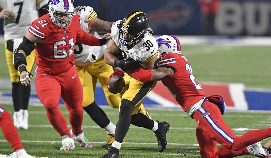 Buffalo Bills free safety Jordan Poyer, right, forces a fumble by Pittsburgh Steelers running back James Conner (30) during the first half of an NFL football game in Orchard Park, N.Y., Sunday, Dec. 13, 2020. The ball was recovered by the Steelers. (AP Photo/Adrian Kraus)