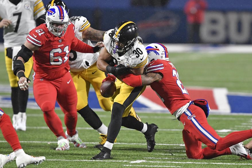 Buffalo Bills free safety Jordan Poyer, right, forces a fumble by Pittsburgh Steelers running back James Conner (30) during the first half of an NFL football game in Orchard Park, N.Y., Sunday, Dec. 13, 2020. The ball was recovered by the Steelers. (AP Photo/Adrian Kraus)