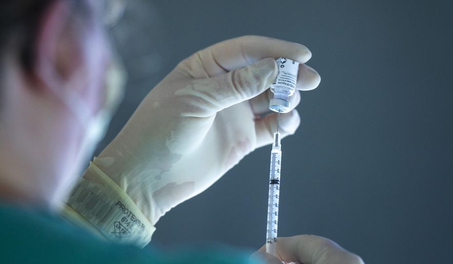 A vial of the Pfizer-BioNTech COVID-19 vaccine is drawn into a syringe, Monday, Dec. 14, 2020, on the 12th floor of the University of Iowa Stead Family Children's Hospital in Iowa City, Iowa. (Joseph Cress/Iowa City Press-Citizen via AP)