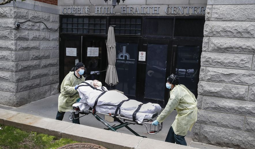In this Friday, April 17, 2020, photo, a patient is wheeled out of the Cobble Hill Health Center nursing home by emergency medical workers in the Brooklyn borough of New York. After 100,000 deaths ravaged the nation’s nursing homes and pushed them to the front of the vaccine line, they now face a vexing problem: Skeptical residents and workers balking at getting the shots. (AP Photo/John Minchillo) **FILE**