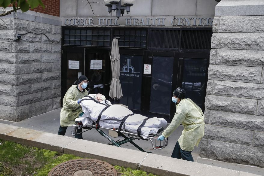 In this Friday, April 17, 2020, photo, a patient is wheeled out of the Cobble Hill Health Center nursing home by emergency medical workers in the Brooklyn borough of New York. After 100,000 deaths ravaged the nation’s nursing homes and pushed them to the front of the vaccine line, they now face a vexing problem: Skeptical residents and workers balking at getting the shots. (AP Photo/John Minchillo) **FILE**