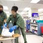In this image provided by Christus St. Vincent Regional Medical Center, pharmacy staff members unpack the first shipment of COVID-19 vaccines at the hospital in Santa Fe, New Mexico, on Monday, Dec. 14, 2020. The medical center was the first in New Mexico to receive doses as hospitals elsewhere around the state prepared for deliveries later this week. (Christus St. Vincent Regional Medical Center via AP)