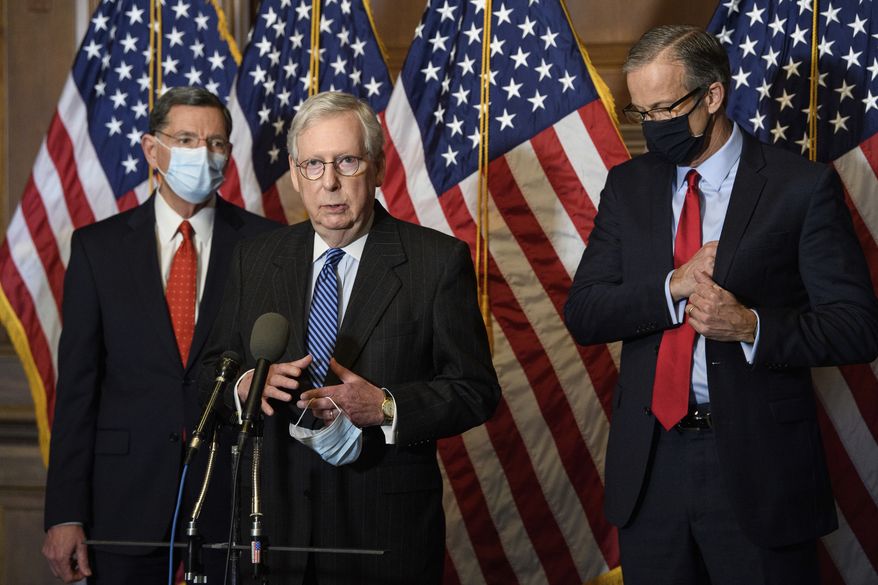 Senate Majority Leader Mitch McConnell of Ky., speaks during a news conference with other Senate Republicans on Capitol Hill in Washington, Tuesday, Dec. 15, 2020. Sen. John Barrasso, R-Wyo., left, and John Thune, R-S.D., right listen. (Nicholas Kamm/Pool via AP)