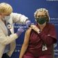 Tami Jeffries, R.N., administers the first locally-available dose of the Pfizer-BioNTech COVID-19 vaccine to ICU respiratory therapist Sue Gallagher at Mary Washington Hospital in Fredericksburg, Va. on Tuesday, Dec. 15, 2020. (Mike Morones/The Free Lance-Star via AP)