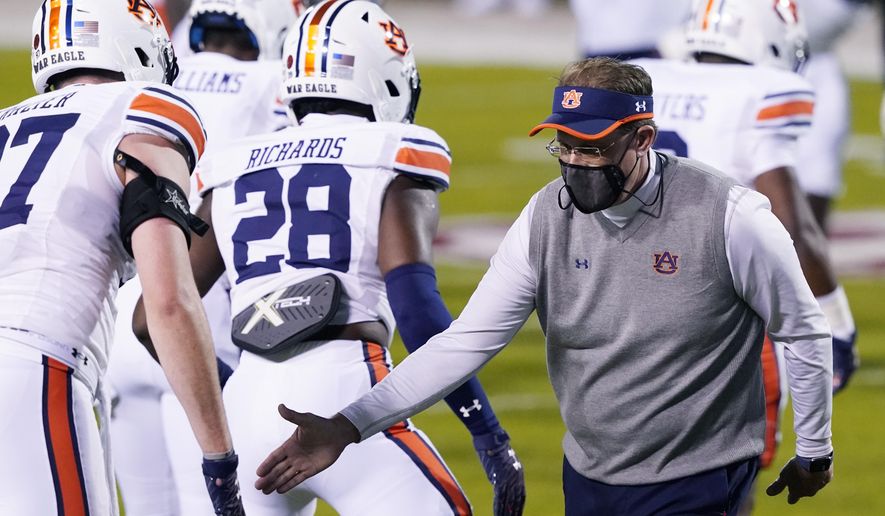 Then Auburn head coach Gus Malzahn wishes players good luck during warmups prior to an NCAA college football game against Mississippi State, Saturday, Dec. 12, 2020, in Starkville, Miss. Auburn athletic director Allen Greene announced the coach's firing on Sunday, Dec. 13, 2020, a day after the Tigers finished the regular season with a 24-10 victory over Mississippi State. (AP Photo/Rogelio V. Solis)