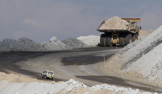 In this Sept. 11, 2012, file photo, a four-wheel-drive vehicle follows a large mining truck as it makes its way to the top of a Boggabri coal mine near Gunnedah, Australia, 450 kilometers (280 miles) northwest of Sydney. Australia’s prime minister said Tuesday, Dec. 15, 2020, that China would be in breach of World Trade Organization rules as well as a bilateral free trade agreement if it banned Australian coal. (AP Photo/Rob Griffith, File)