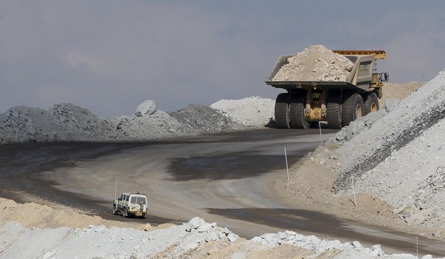 In this Sept. 11, 2012, file photo, a four-wheel-drive vehicle follows a large mining truck as it makes its way to the top of a Boggabri coal mine near Gunnedah, Australia, 450 kilometers (280 miles) northwest of Sydney. Australia’s prime minister said Tuesday, Dec. 15, 2020, that China would be in breach of World Trade Organization rules as well as a bilateral free trade agreement if it banned Australian coal. (AP Photo/Rob Griffith, File)