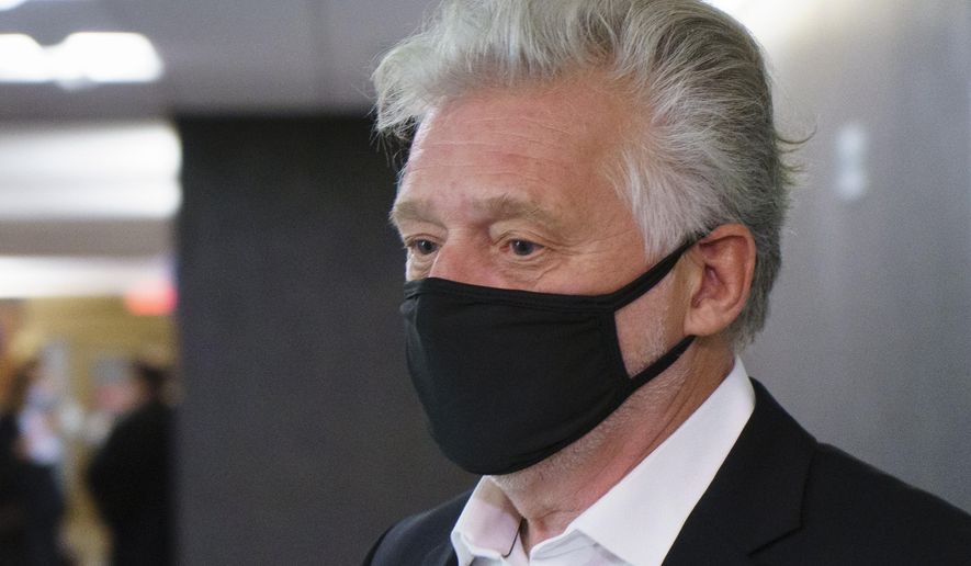 Just for Laughs founder Gilbert Rozon walks the hall of the courthouse as he arrives for the beginning of his sexual assault trial in Montreal on Tuesday, Oct. 13, 2020. (Paul Chiasson/The Canadian Press via AP)