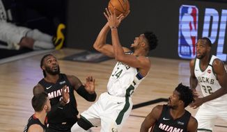 FILE - Miami Heat&#39;s Goran Dragic, bottom left, Jae Crowder, top left, and Jimmy Butler (22) defend as Milwaukee Bucks&#39; Giannis Antetokounmpo (34) shoots during the first half of an NBA basketball conference semifinal playoff game inin Lake Buena Vista, Fla., in this Monday, Aug. 31, 2020, file photo. Bucks Khris Middleton, right rear, looks on. Having the NBA’s best regular-season record and the league’s MVP each of the last two years hasn’t paid off for the Bucks in the playoffs. They’re hoping an offseason overhaul of their roster will help them earn the title that has eluded this franchise since 1971 and make sure two-time reigning MVP Giannis Antetokounmpo stays in Milwaukee for years to come.(AP Photo/Mark J. Terrill, File)