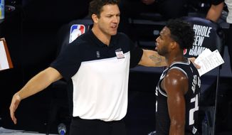 FILE - In this Thursday, Aug. 13, 2020, file photo, Sacramento Kings head coach Luke Walton, left, talks with Buddy Hield during the fourth quarter of an NBA basketball game against the Los Angeles Lakers, in Lake Buena Vista, Fla. The hope for the Sacramento Kings&#39; 2020-21 season is that speeding up their play on the court will help quicken the turnaround for a franchise that hasn&#39;t been to the playoffs since 2006. (Kevin C. Cox/Pool Photo via AP, File)