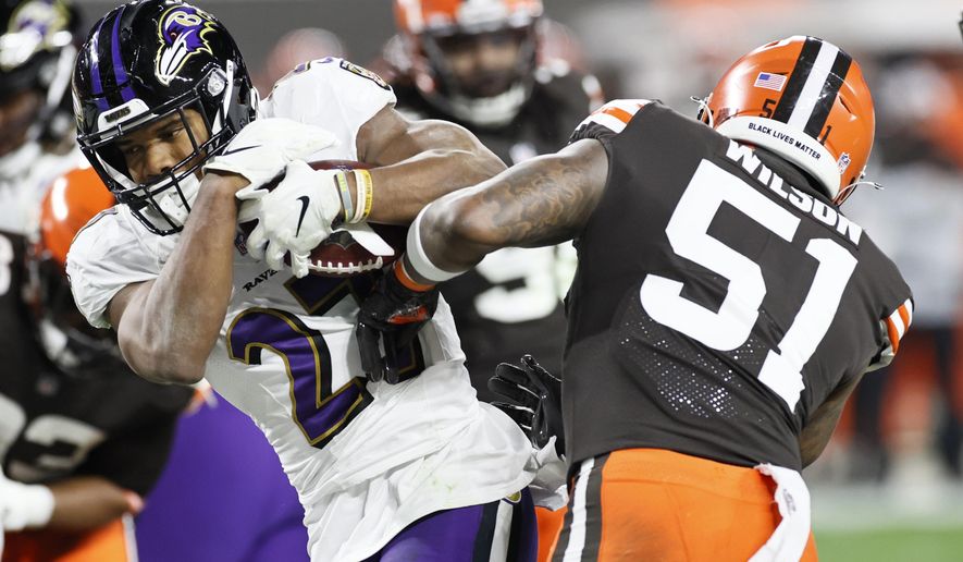 Baltimore Ravens running back J.K. Dobbins (27) rushes for a one-yard touchdown against Cleveland Browns linebacker Mack Wilson (51) during the second half of an NFL football, Monday, Dec. 14, 2020, in Cleveland. (AP Photo/Ron Schwane)