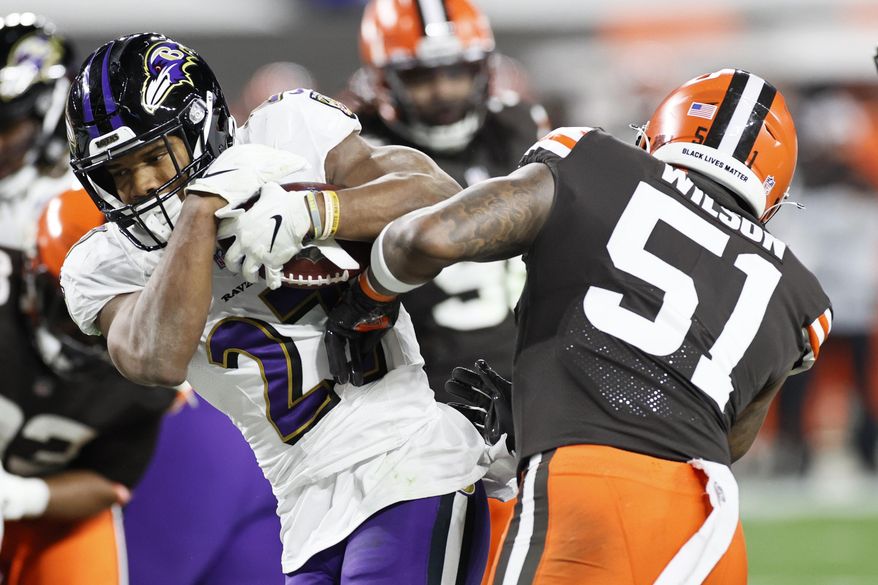 Baltimore Ravens running back J.K. Dobbins (27) rushes for a one-yard touchdown against Cleveland Browns linebacker Mack Wilson (51) during the second half of an NFL football, Monday, Dec. 14, 2020, in Cleveland. (AP Photo/Ron Schwane)