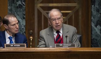 FILE - In this Tuesday, Jan. 29, 2019, file photo, Sen. Chuck Grassley, R-Iowa, center, chairman of the Senate Finance Committee, is joined at left by Sen. Ron Wyden, D-Ore., the ranking member, at a hearing on the high price of prescription drugs, on Capitol Hill in Washington. A bipartisan congressional investigation released Wednesday, Dec. 16, 2020, by Grassley and Wyden, found that key players in the nation’s opioid industry have spent $65 million since 1997 funding nonprofits that advocate treating pain with medications, a strategy intended to boost the sale of prescription painkillers. (AP Photo/J. Scott Applewhite, File)