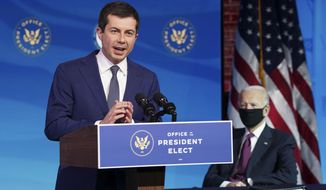 Former South Bend, Ind. Mayor Pete Buttigieg, President-elect Joe Biden&#x27;s nominee to be transportation secretary reacts to his nomination as Biden looks on during a news conference at The Queen theater in Wilmington, Del., Wednesday, Dec. 16, 2020. (Kevin Lamarque/Pool via AP)