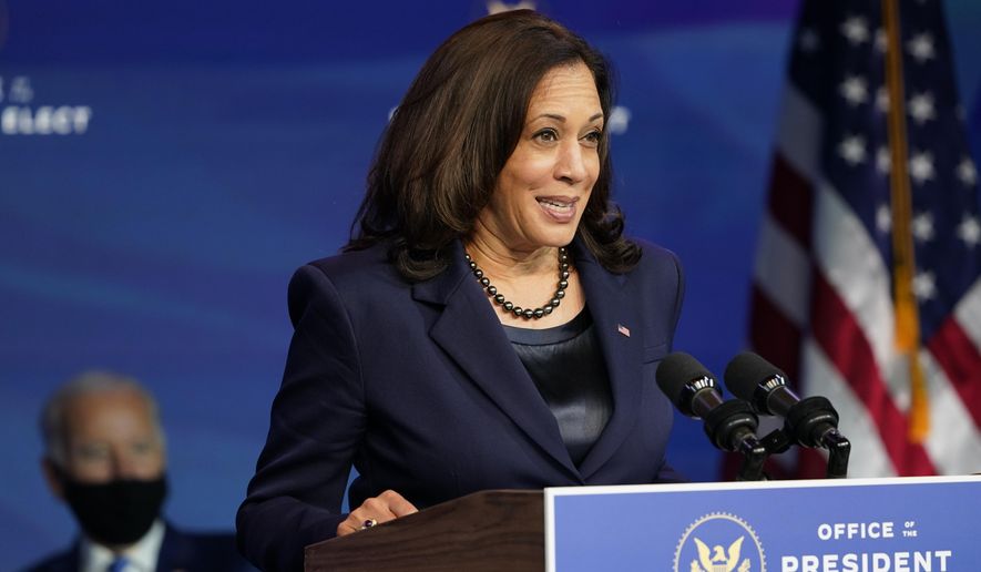 President-elect Joe Biden listens as Vice President-elect Kamala Harris speaks during an event at The Queen theater in Wilmington, Del., Friday, Dec. 11, 2020. (AP Photo/Susan Walsh)