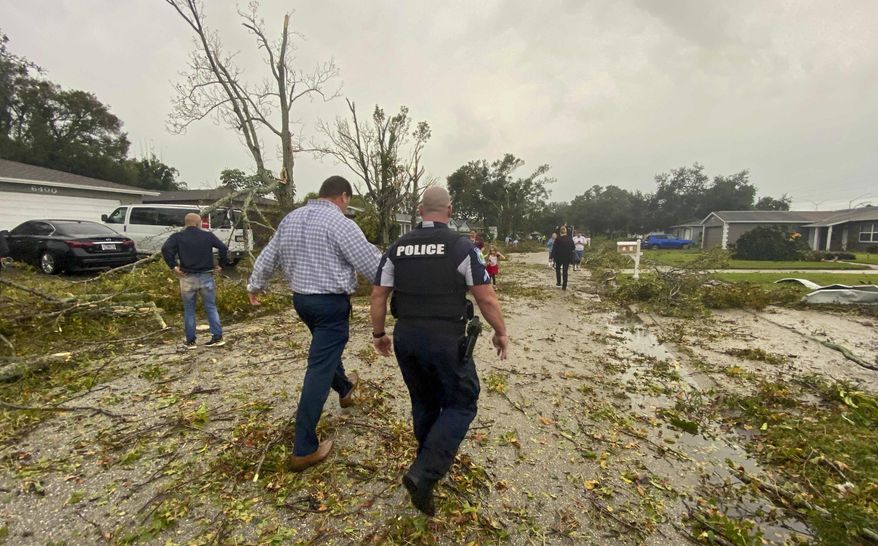 Debris is seen on the ground as residents survey damage along Elmhurst Drive after a possible tornado touched down in the area Wednesday, Dec. 16, 2020, in Pinellas Park, Fla. (James Borchuck/Tampa Bay Times via AP)