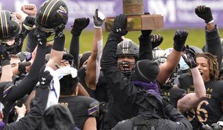 Northwestern football head coach Pat Fitzgerald celebrates with players as he holds the Land of Lincoln Trophy after Northwestern defeated Illinois 28-10 in an NCAA college football game in Evanston, Ill., Saturday, Dec. 12, 2020. (AP Photo/Nam Y. Huh)