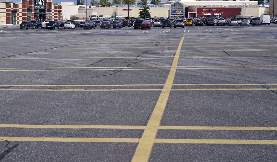 A parking lot nearly empty of the cars of holiday shoppers is shown at the Mall of New Hampshire, Thursday, Dec. 10, 2020, in Manchester, N.H. Retail sales fell 1.1% in November, the biggest drop in seven months, a sign that Americans held back on spending during the start of the holiday shopping season. The U.S. Commerce Department also revised October’s number, saying on Wednesday that retail sales actually fell 0.1% that month, instead of rising 0.3% as it previously reported. (AP Photo/Charles Krupa)