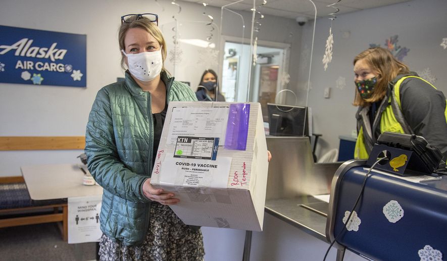 Public Health Nurse 4 Theresa Ruzek collects a shipment of 20 doses of the COVID-19 vaccine from Alaska Air Cargo Station Manager Madison Swafford on Wednesday, Dec. 16, 2020 at Ketchikan International Airport in Ketchikan, Alaska. (Dustin Safranek/Ketchikan Daily News via AP)