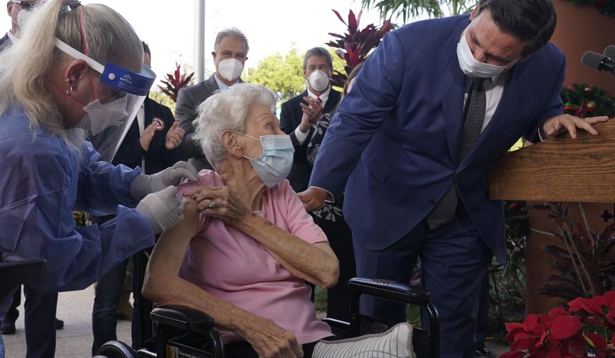 Florida Gov. Ron DeSantis asks Vera Leip, 88, how she feels after nurse Christine Philips, left, administered the Pfizer vaccine at John Knox Village, Wednesday, Dec. 16, 2020, in Pompano Beach, Fla. Nursing home residents and health care workers in Florida began receiving the Pfizer vaccine this week. (AP Photo/Marta Lavandier)