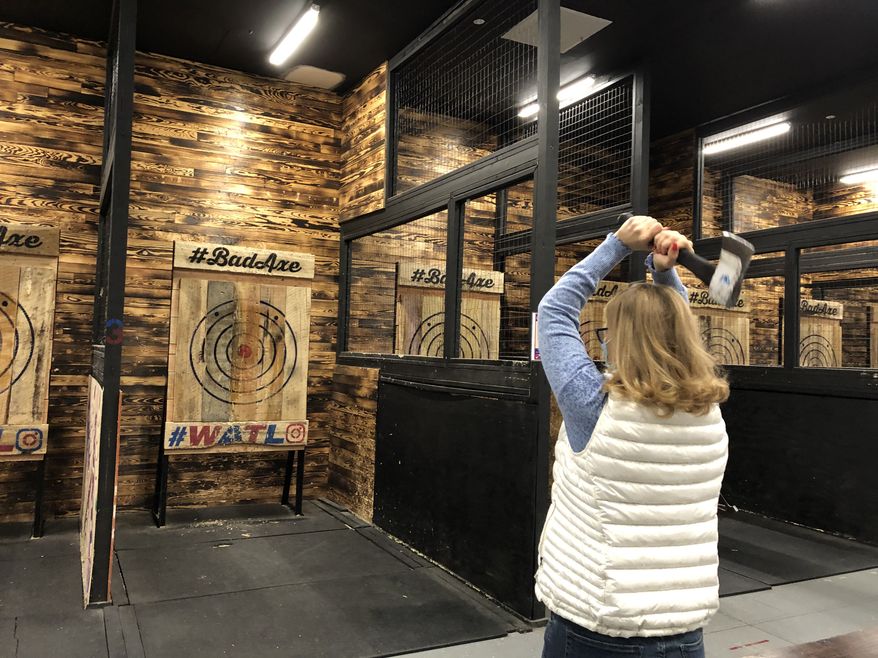 Annika Moje, a resident of Alexandria, Virginia, takes aim while on a "creative" date at the Bad Axe Throwing club in Fairfax, Virginia. (Shen Wu Tan/The Washington Times)