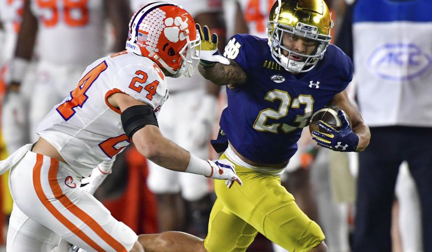 FILE - Notre Dame running back Kyren Williams (23) fends off Clemson Tigers safety Nolan Turner (24) on his way to a touchdown during the first quarter of an NCAA college football game in South Bend, Ind., in this Saturday, Nov. 7, 2020, file photo. The Notre Dame Fighting Irish beat the Clemson Tigers in a thrilling 47-40 shootout earlier this season. The big question now is if they can do it again. (Matt Cashore/Pool Photo via AP, File)