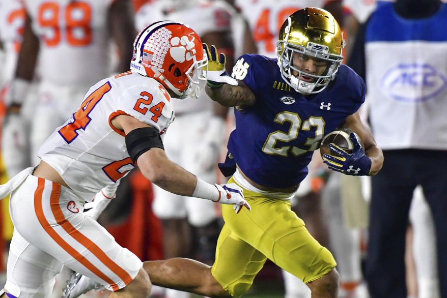 FILE - Notre Dame running back Kyren Williams (23) fends off Clemson Tigers safety Nolan Turner (24) on his way to a touchdown during the first quarter of an NCAA college football game in South Bend, Ind., in this Saturday, Nov. 7, 2020, file photo. The Notre Dame Fighting Irish beat the Clemson Tigers in a thrilling 47-40 shootout earlier this season. The big question now is if they can do it again. (Matt Cashore/Pool Photo via AP, File)